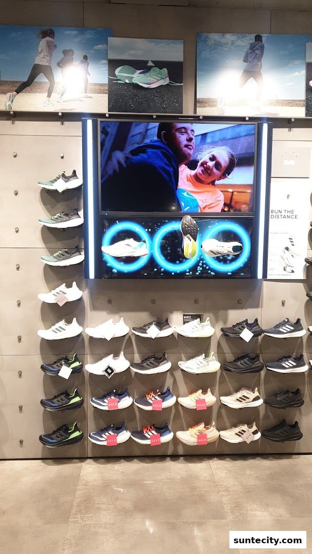 An Adidas store display featuring various running shoes and promotional imagery.