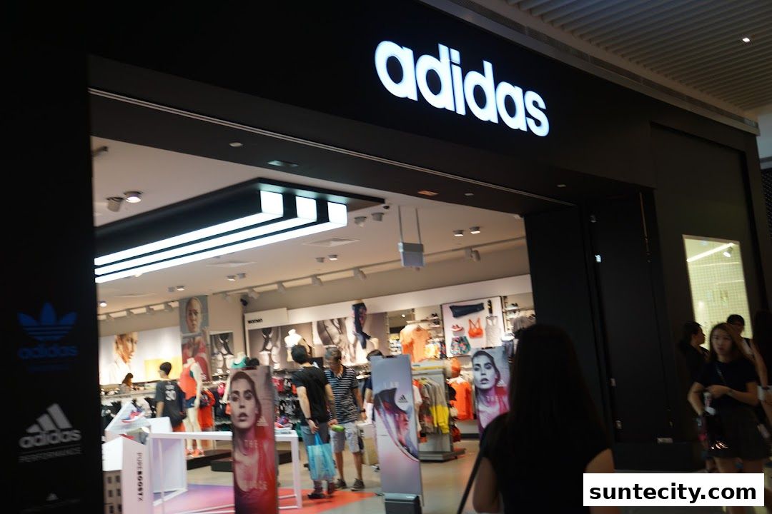 The entrance of an Adidas Performance Store with its iconic logo and displays of athletic wear.