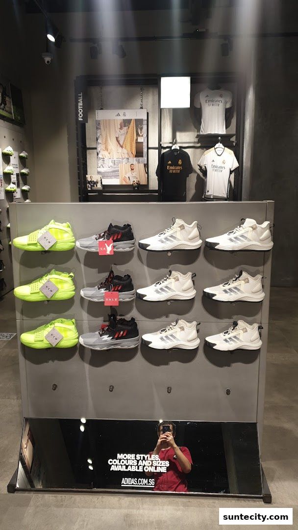 Display of Adidas performance shoes and football jerseys in a retail store.