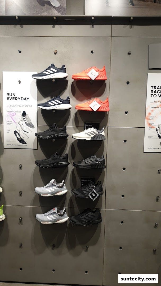 A wall display showcasing various Adidas running shoes in different colors and styles.