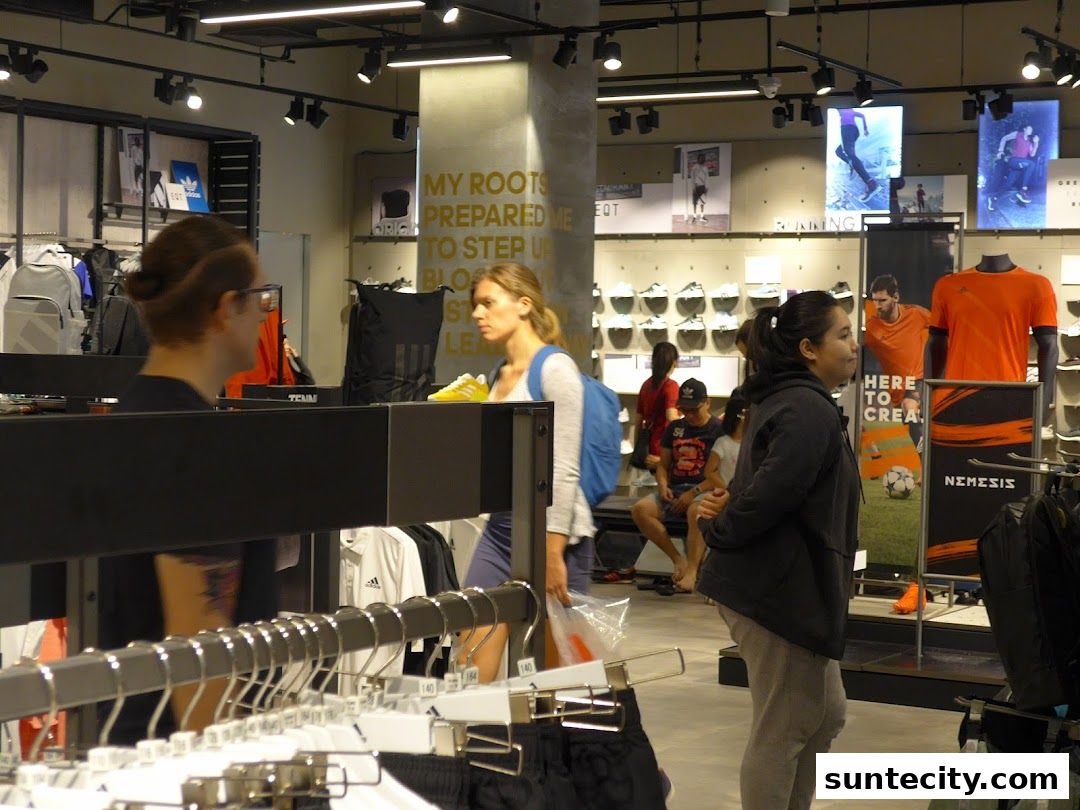 Interior of an Adidas Performance Store with customers browsing merchandise and displays.