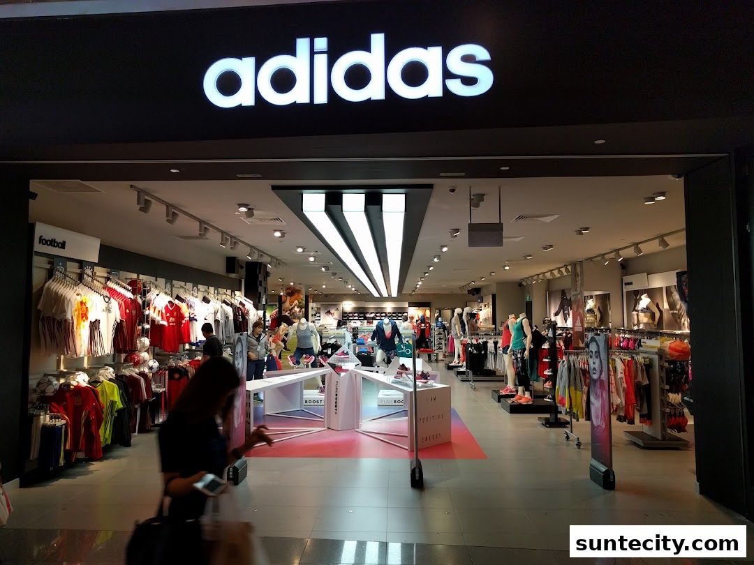 The entrance of an Adidas Performance Store with apparel and mannequins displayed inside.