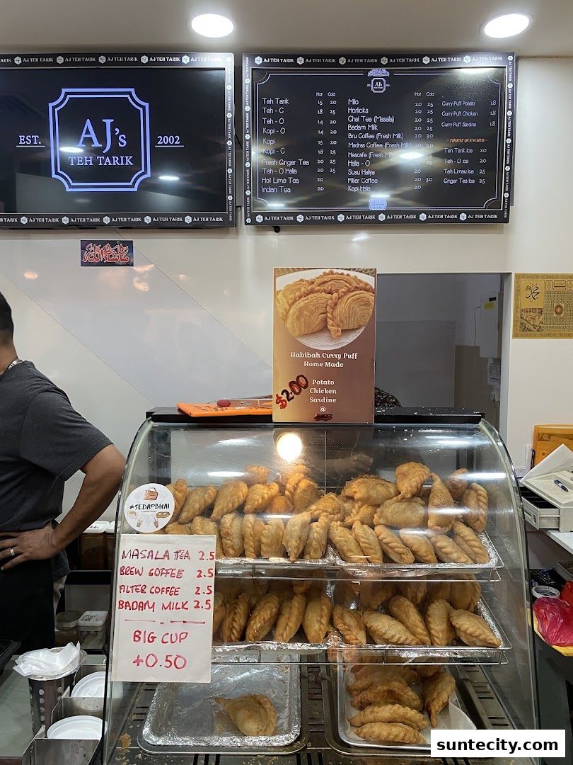 A display case filled with savory pastries and a menu board showing drinks and prices.