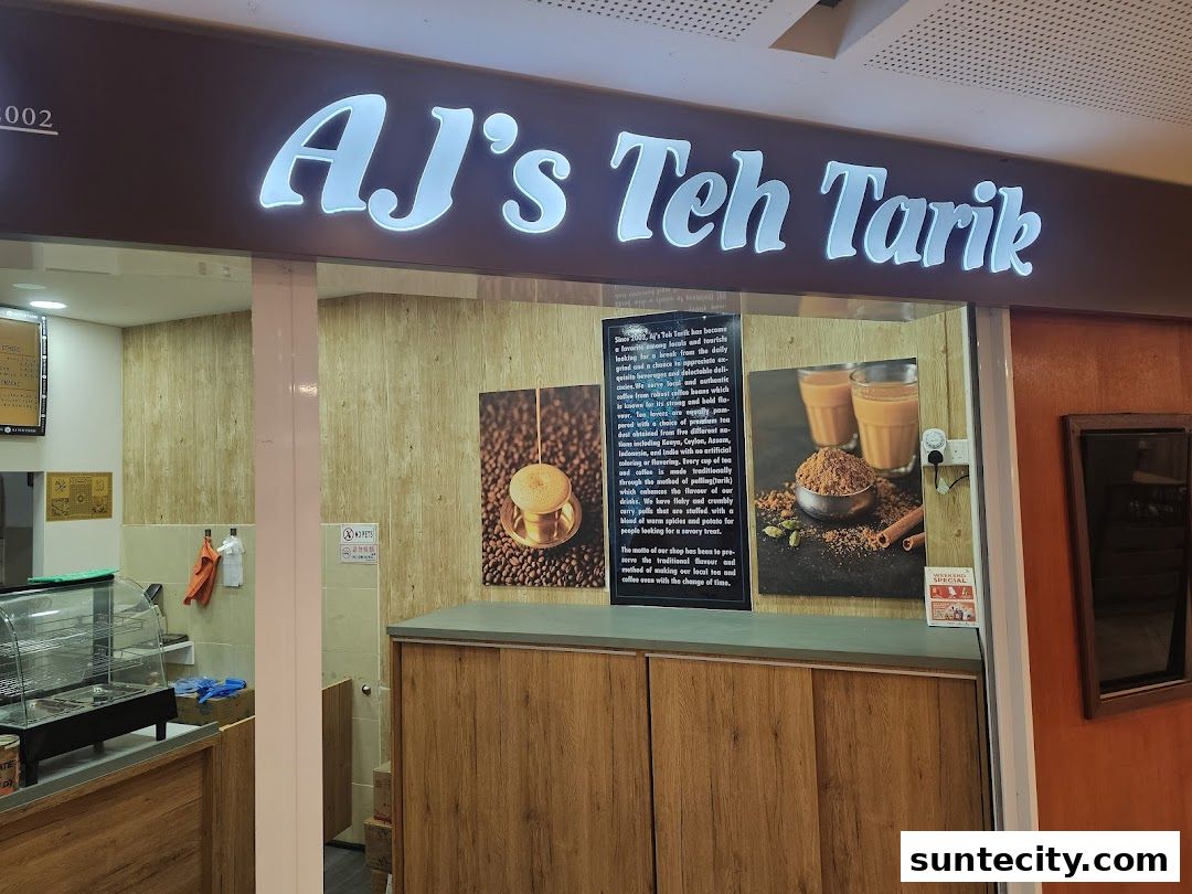 The storefront of AJ's Teh Tarik, featuring its illuminated sign and promotional images.