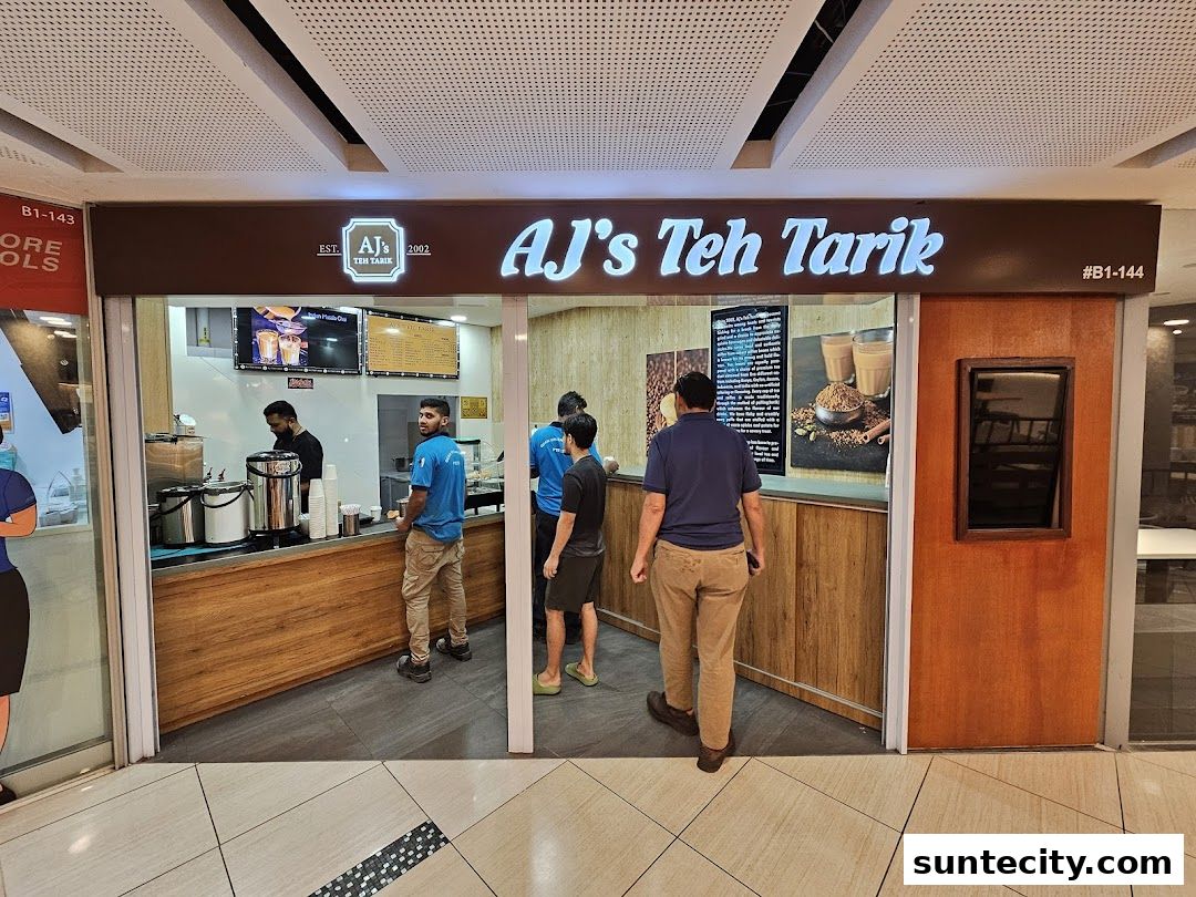 The exterior of AJ's Teh Tarik shop with customers and staff visible.