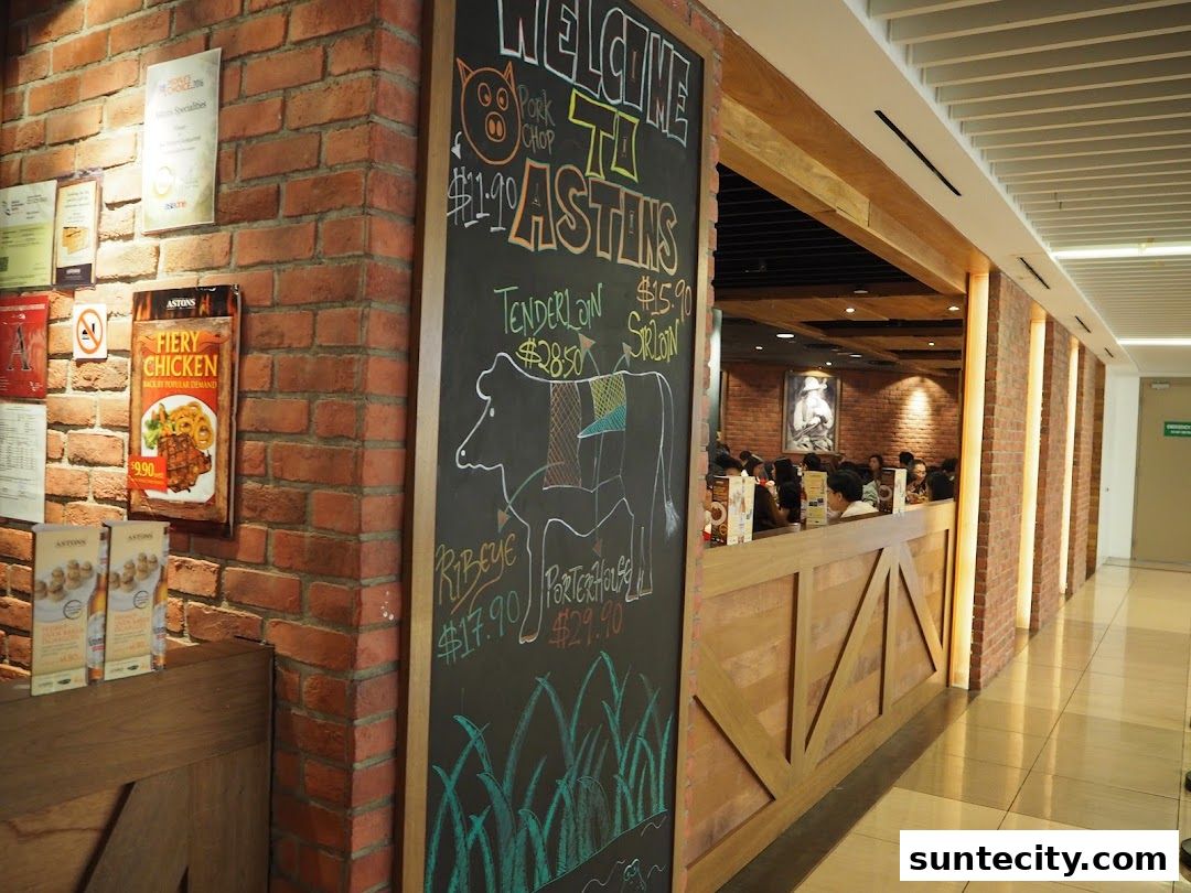 A restaurant entrance with a chalkboard menu featuring meat cuts and a 'Fiery Chicken' advertisement.