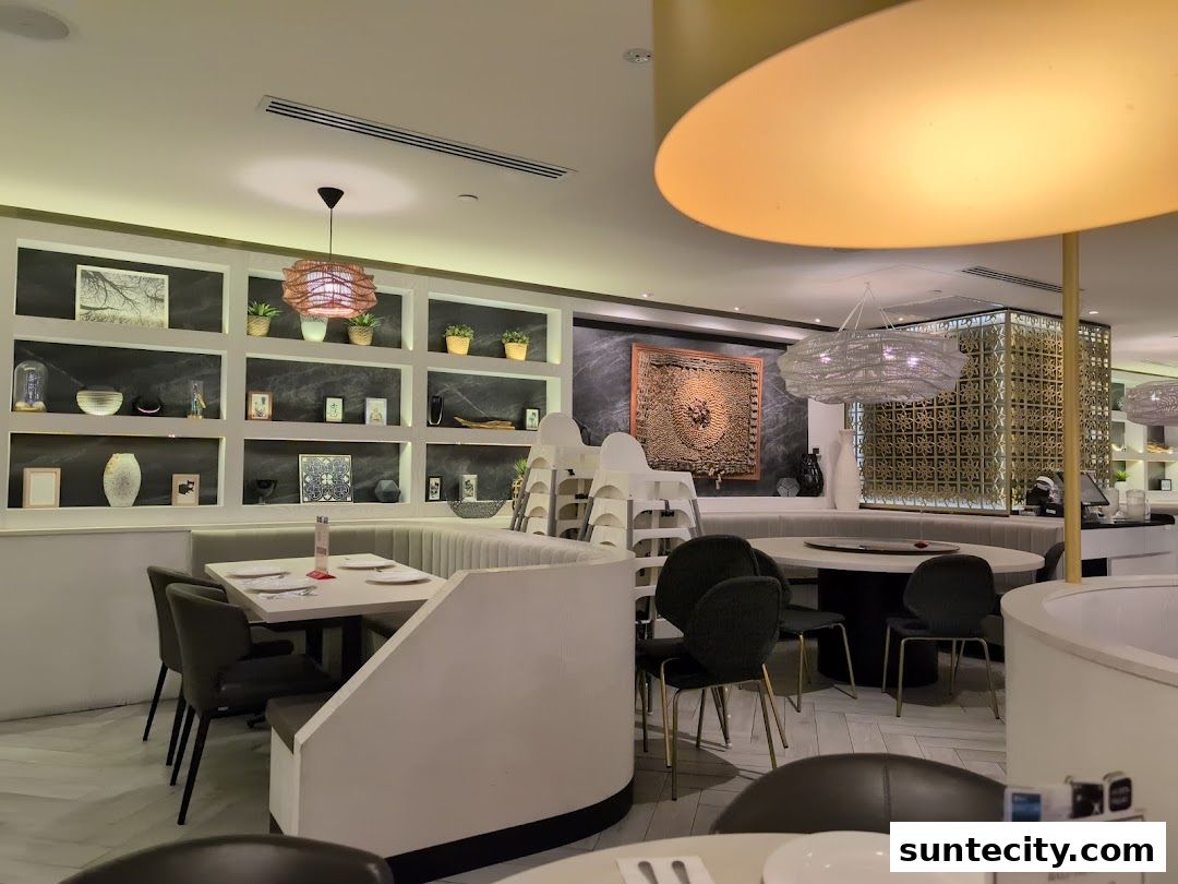 Interior view of a modern restaurant with elegant seating and decorative shelves.