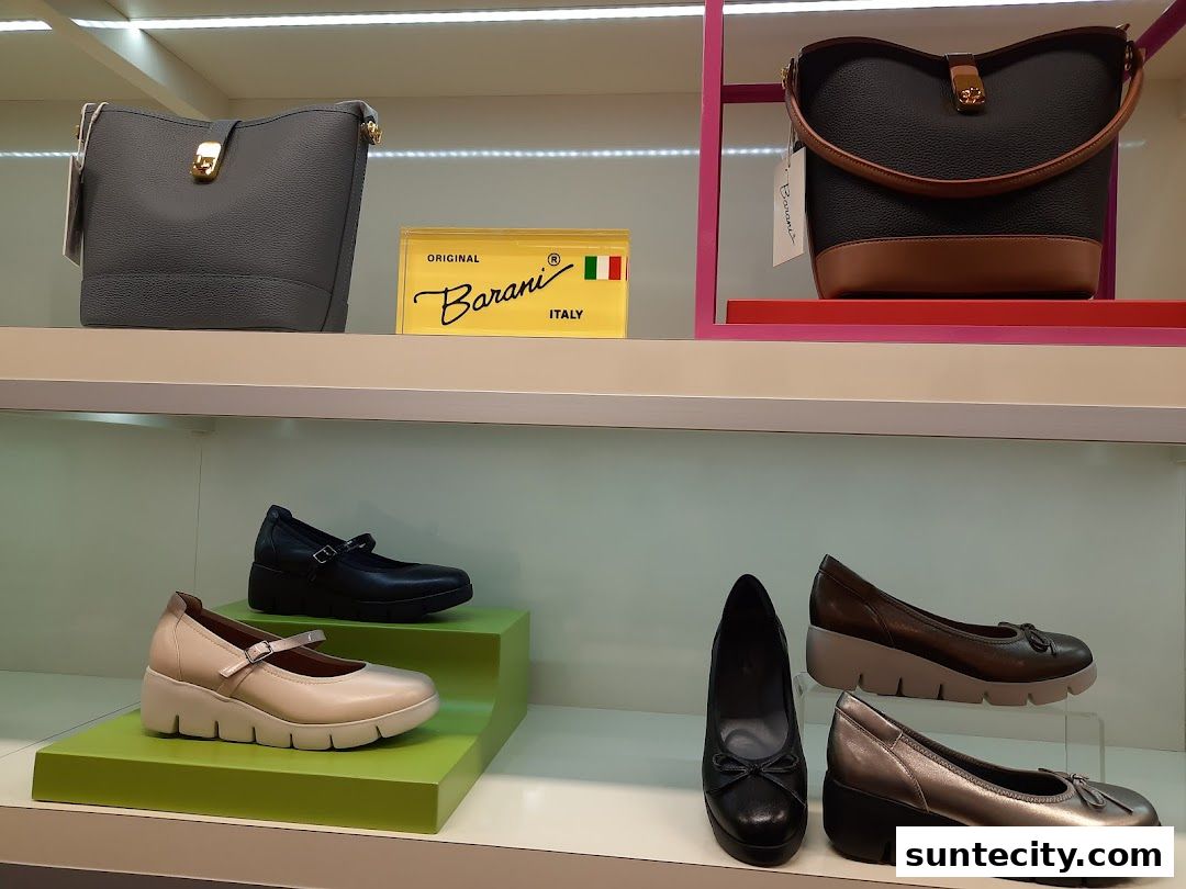 A display of stylish Barani handbags and comfortable wedge shoes in various colors.