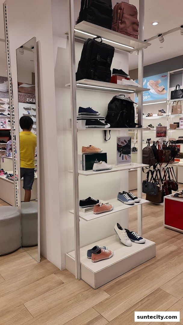 Interior view of a Bata shoe store showcasing various footwear and bags on display shelves.