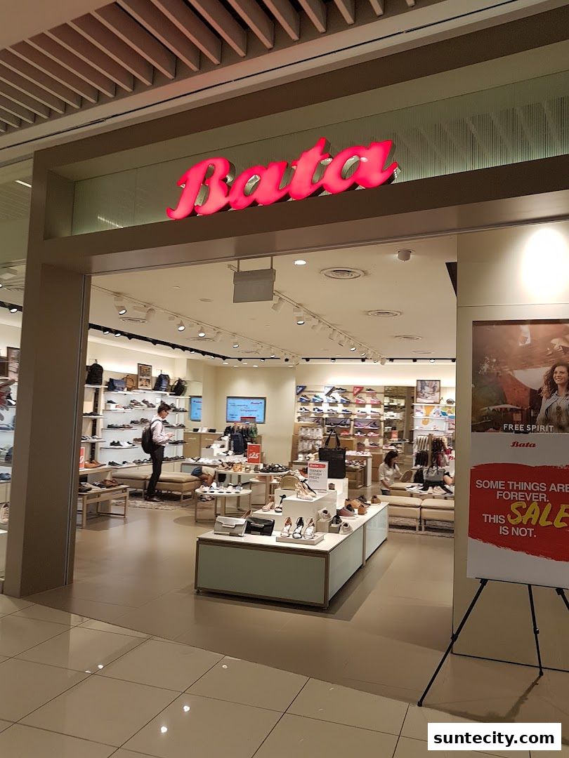 The entrance to a Bata shoe store, showcasing various footwear displays and a sale sign.