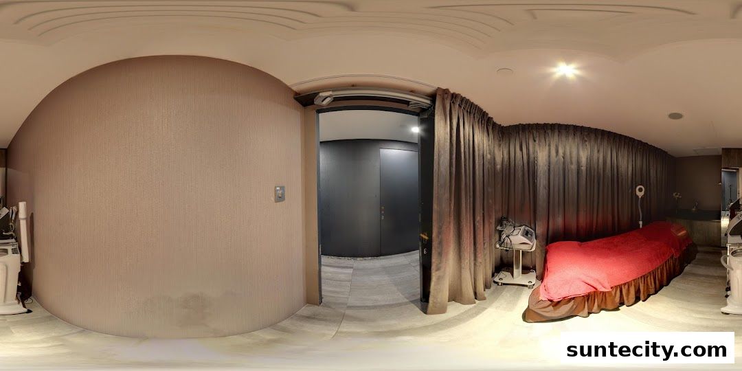 Interior view of a treatment room with a massage bed and beauty equipment.