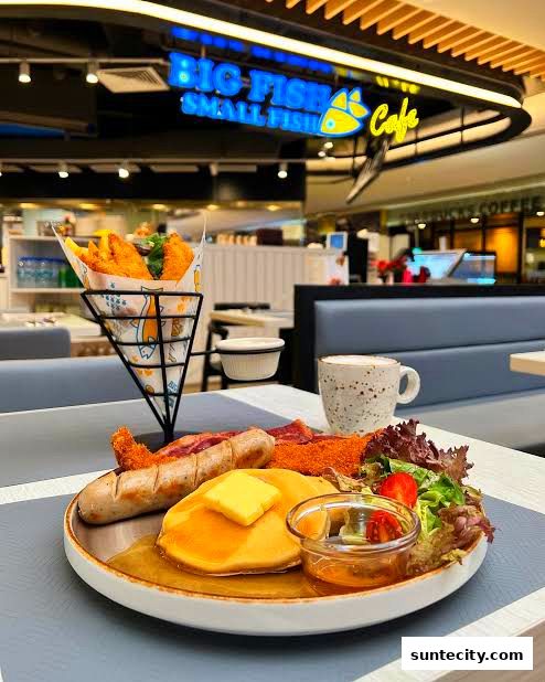 A hearty breakfast platter with pancakes, sausage, and fried fish is served at Big Fish Small Fish Cafe.