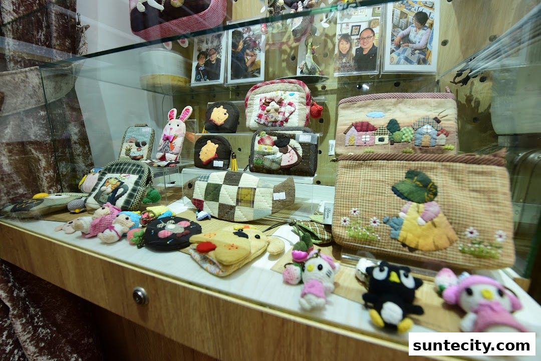 A display case filled with handmade pouches and plush toys featuring cute animal and cartoon designs.