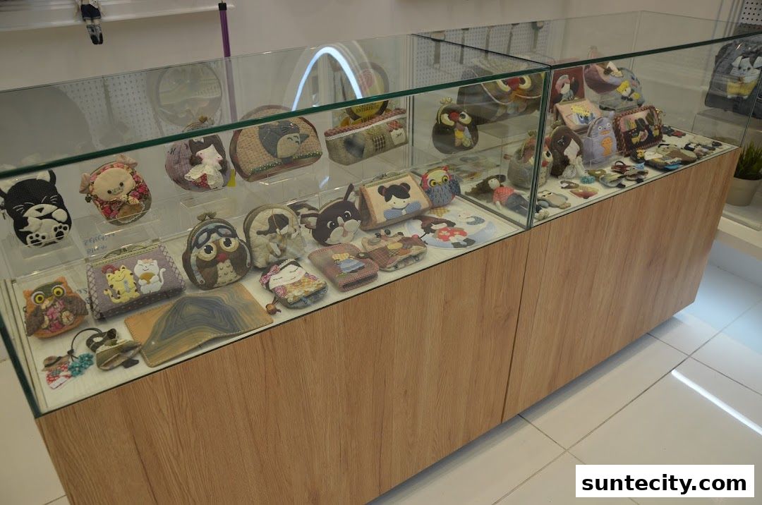 A display case filled with various cute, handmade pouches and accessories featuring animal and character designs.