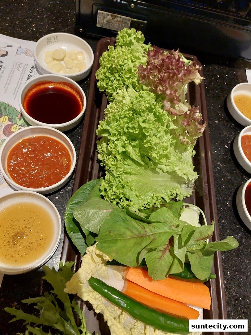 A platter of fresh vegetables and dipping sauces, ready for Korean BBQ.