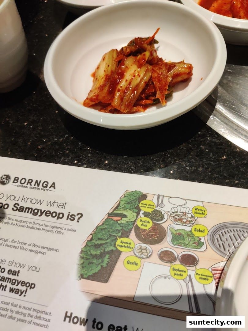 A close-up of Korean kimchi served in a white bowl with a menu detailing how to eat Woo Samgyeop.