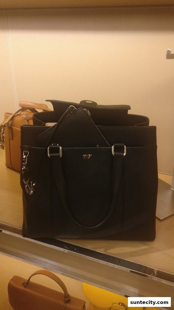 A display of elegant leather handbags, featuring a prominent black tote bag with a smaller pouch.