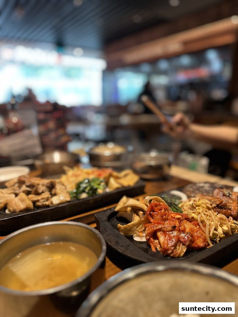 A close-up of Korean BBQ dishes with kimchi, meat, and side dishes.
