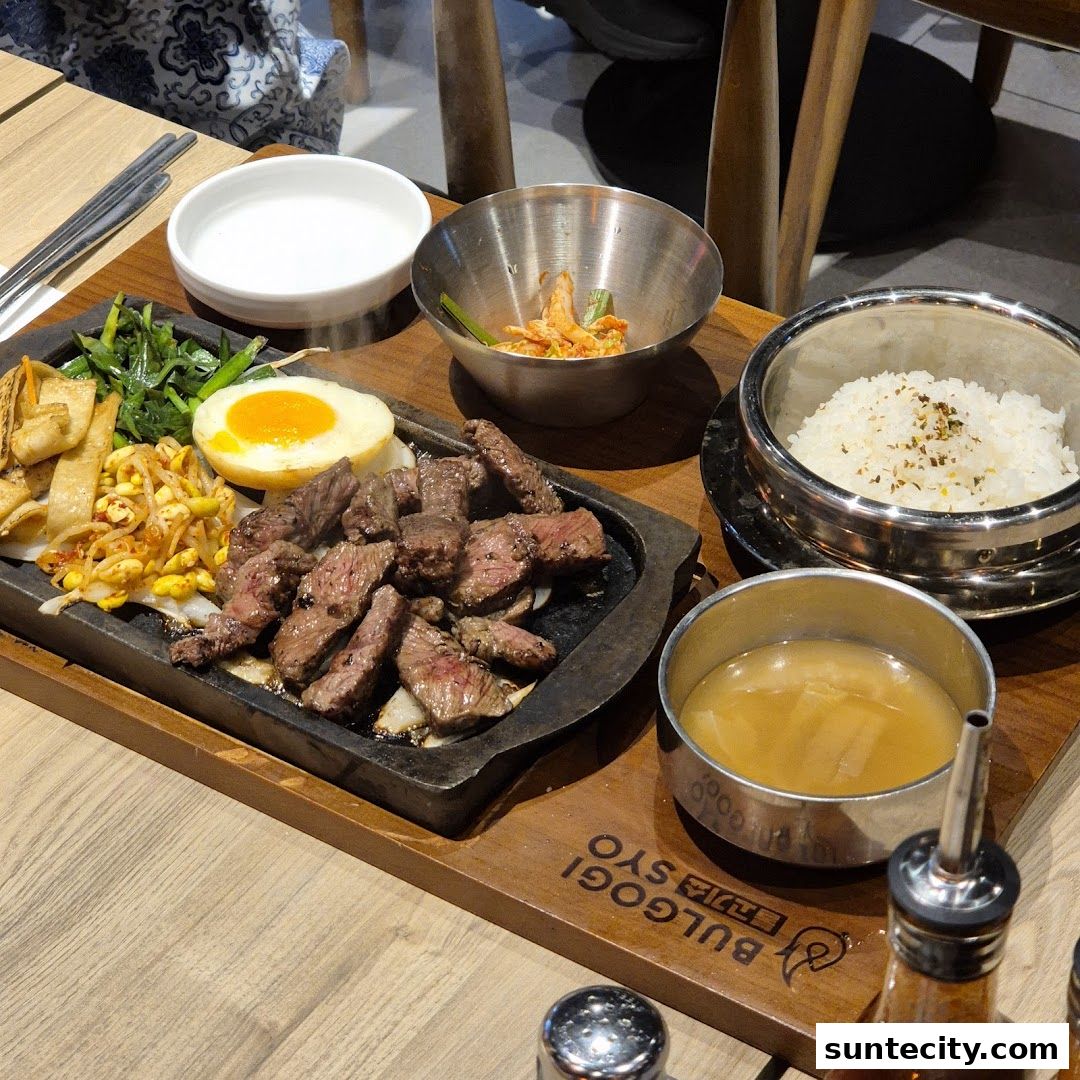 A sizzling bulgogi dish served with rice, kimchi, and other Korean side dishes.