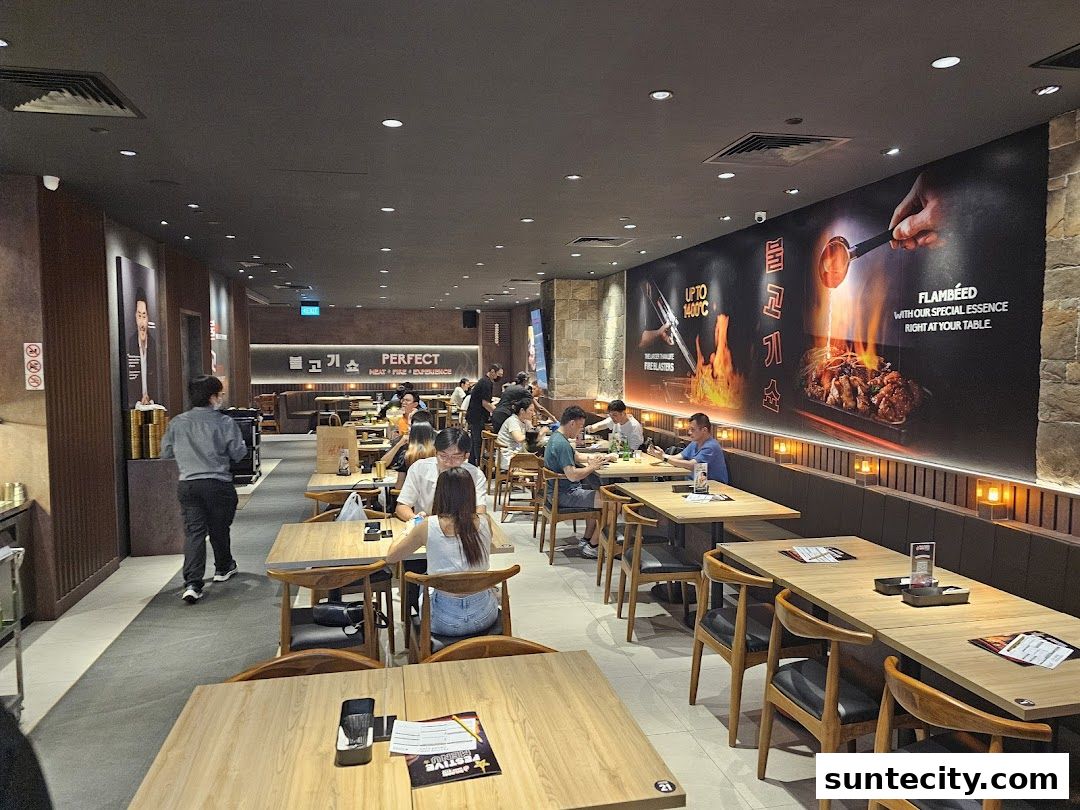 Interior view of a busy Korean BBQ restaurant with diners seated at tables.