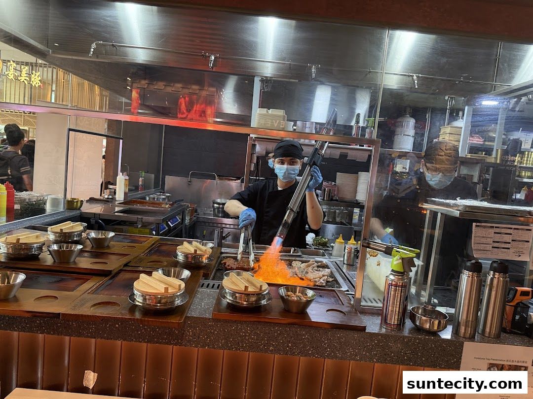 Chefs prepare food with a blowtorch in a modern restaurant kitchen.
