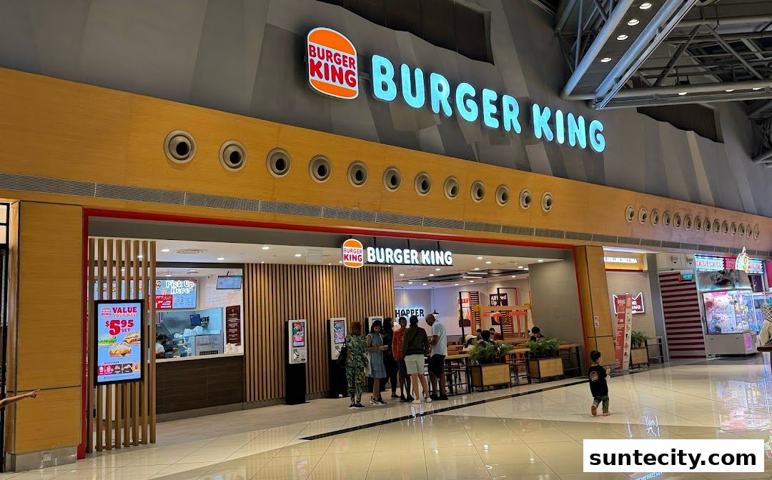 Burger King restaurant entrance with a queue of customers and prominent signage.