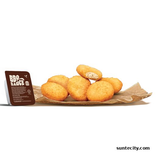 A pile of golden-brown chicken nuggets with a side of BBQ sauce.