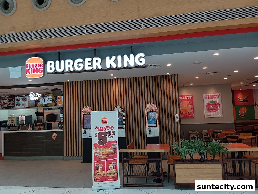 The exterior of a Burger King restaurant with its iconic signage and a promotional stand.