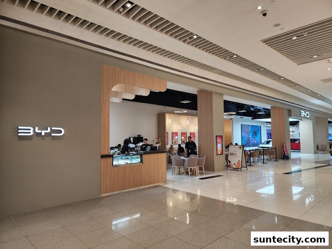 Interior view of a BYD showroom with a cafe counter and seating area.