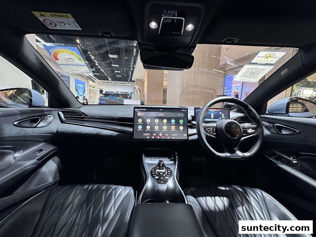 Interior view of a modern car with a large touchscreen and digital dashboard.