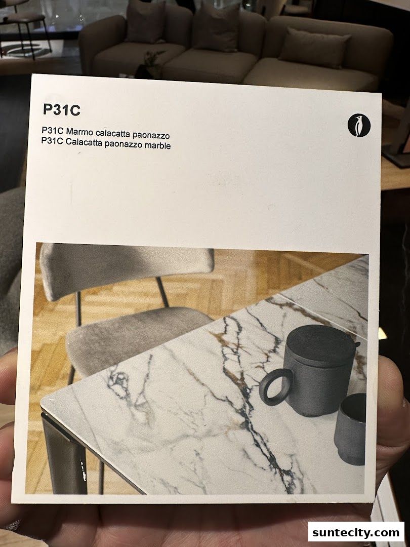 A card showcasing a marble tabletop with a mug and cup, with furniture in the background.