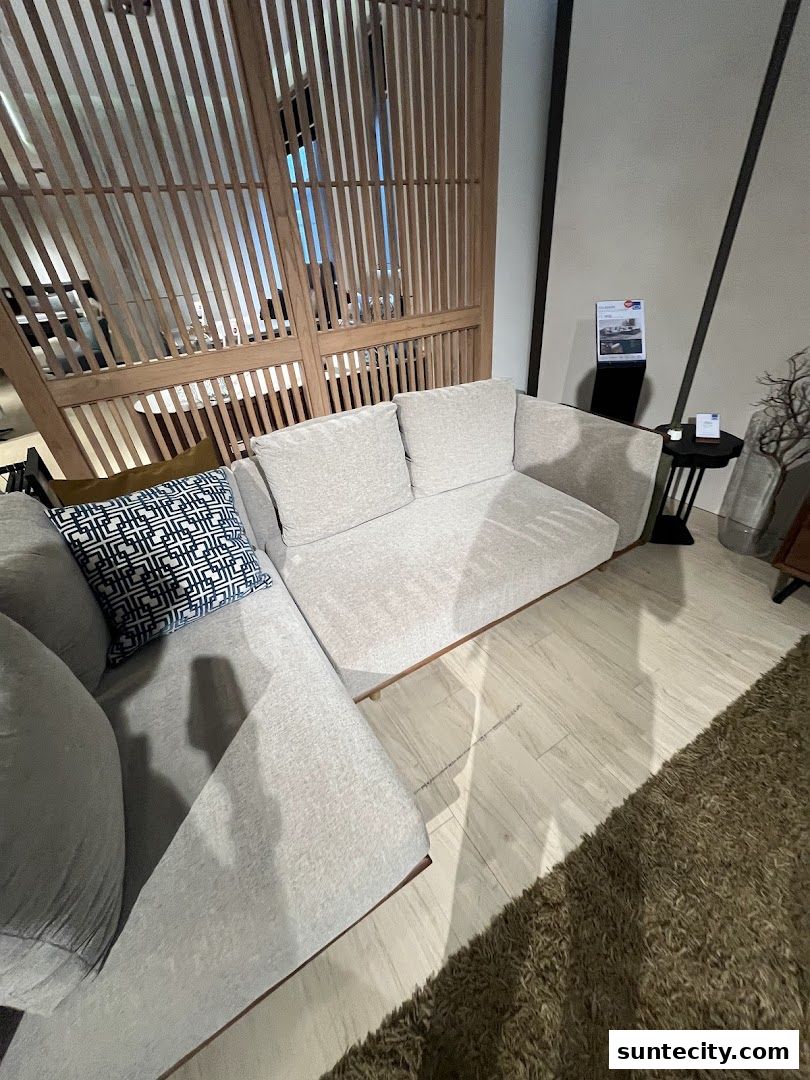 A stylish sectional sofa with decorative pillows in a modern showroom setting.