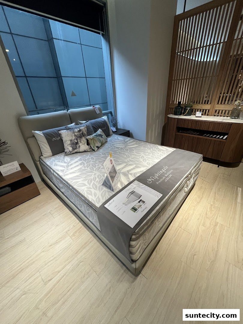 A beautifully made bed with a mattress and pillows in a modern showroom setting.