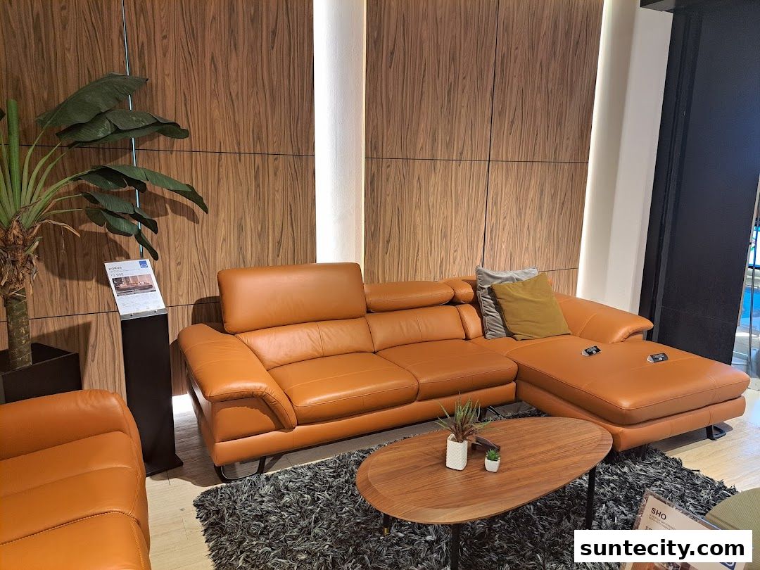 A stylish orange leather sectional sofa with a wooden coffee table and plant.