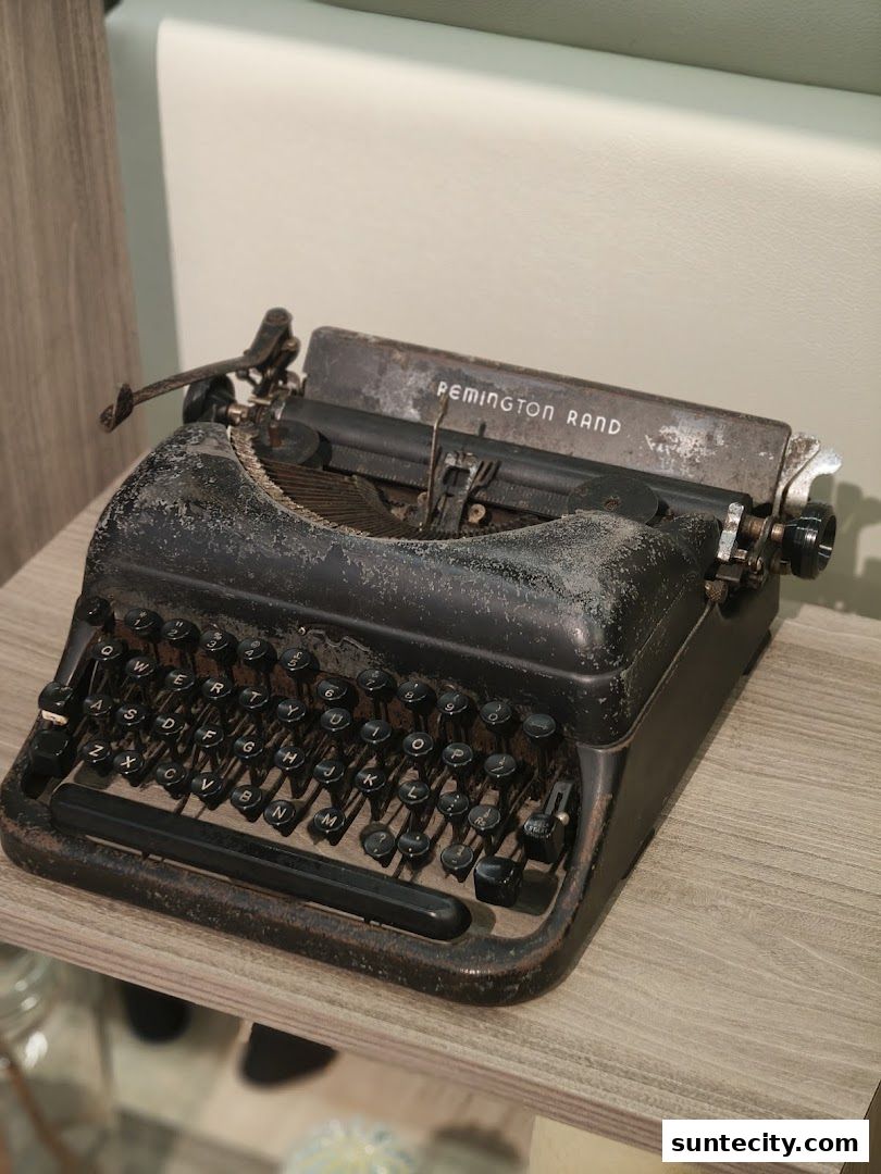 A vintage Remington Rand typewriter sits on a wooden shelf.