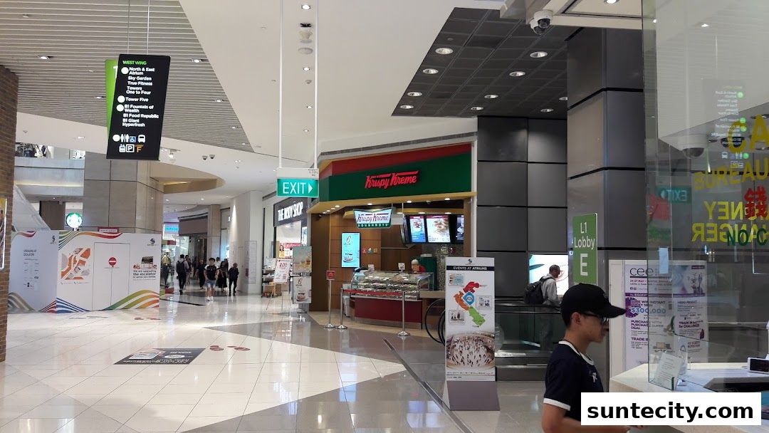 A shopping mall interior with various shops including Krispy Kreme and The Body Shop.