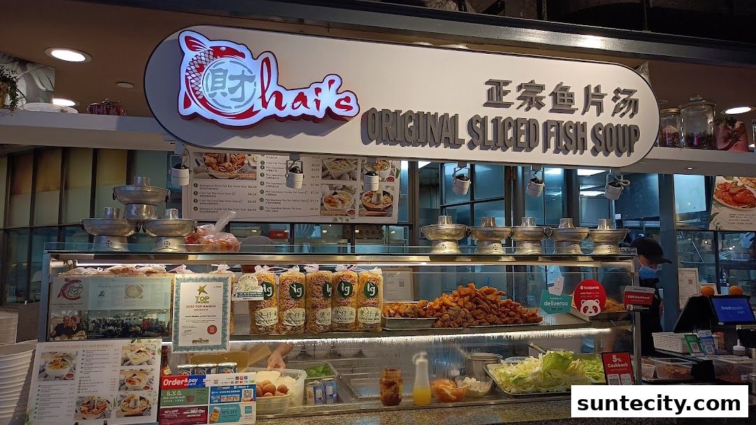 A food stall with a prominent sign for 'Chais Original Sliced Fish Soup' and various dishes displayed.