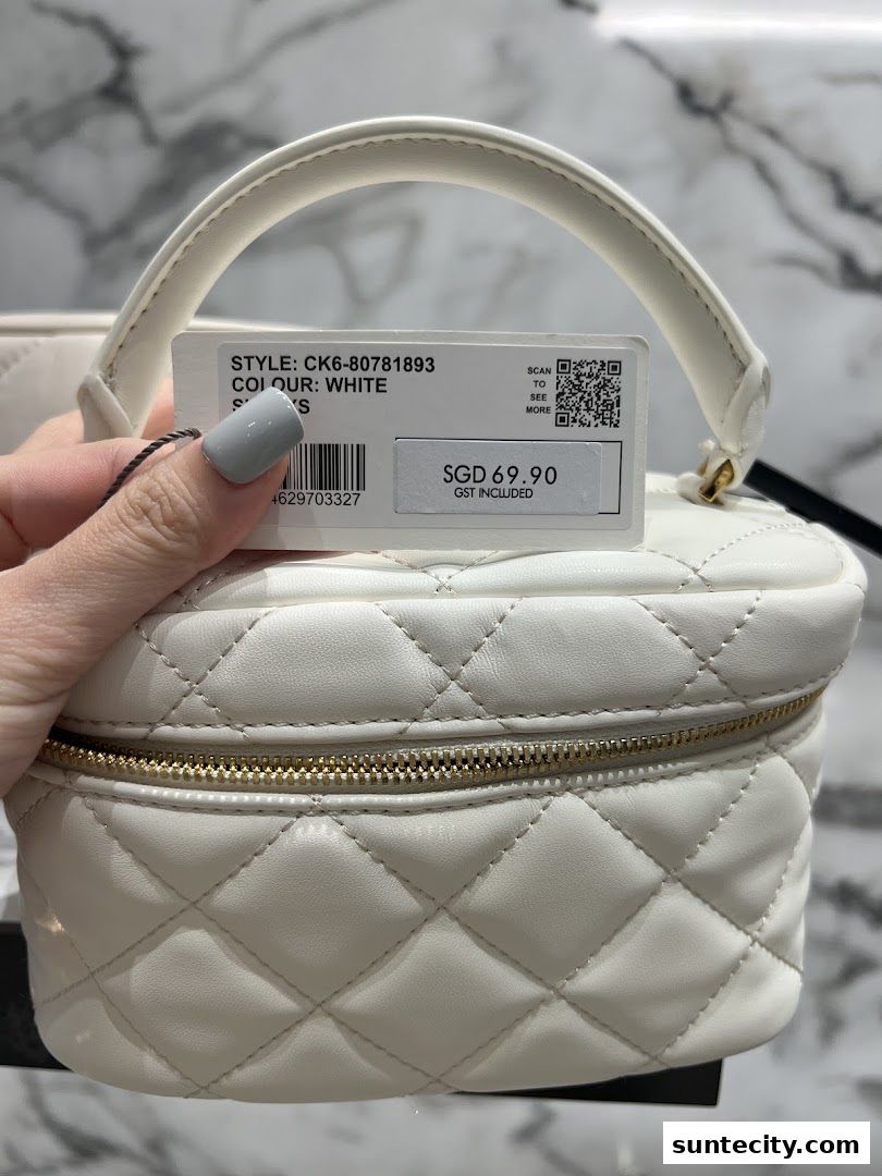 A hand holds a white quilted vanity bag with a price tag showing SGD 69.90.