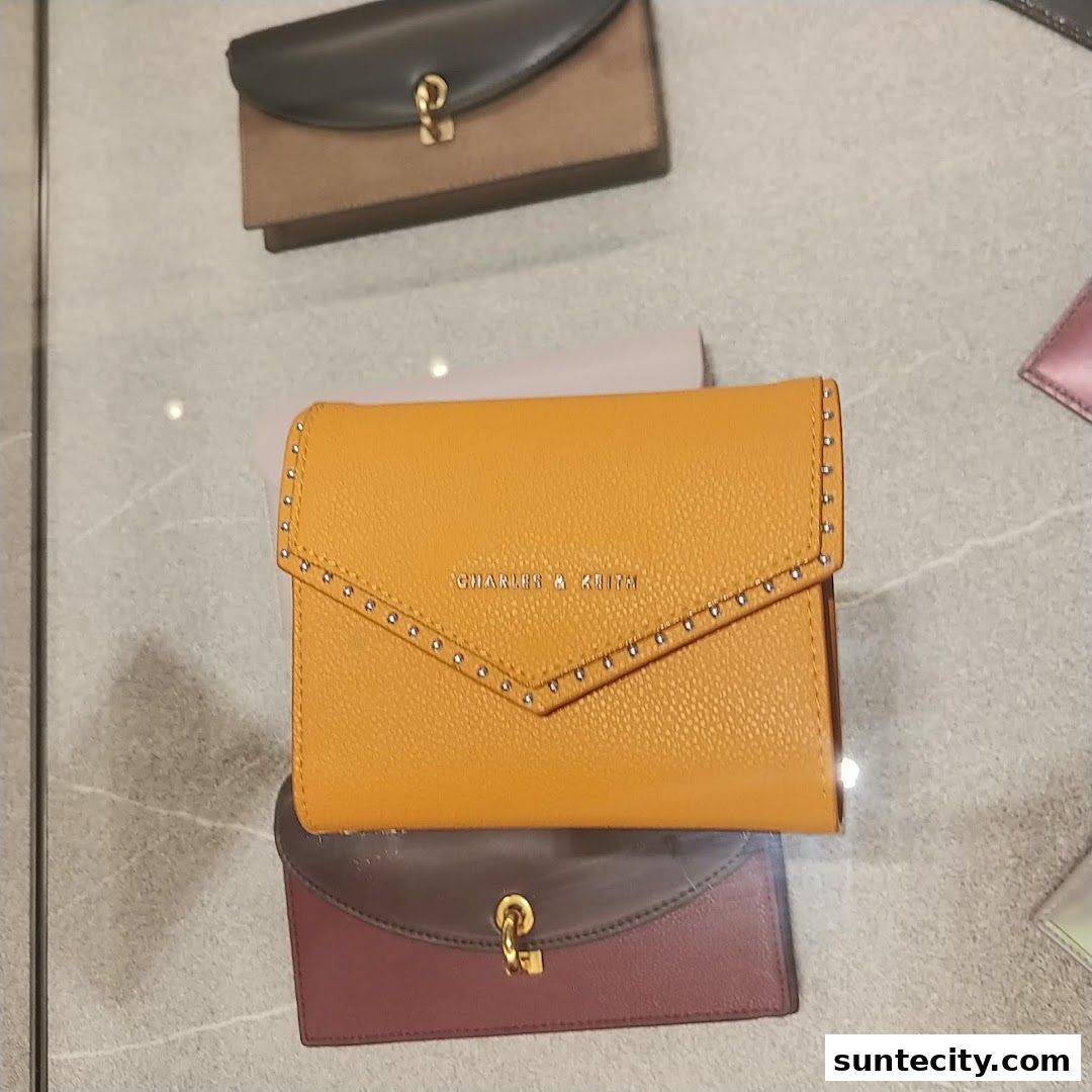 A close-up shot of several stylish wallets, with a prominent yellow one in the center.