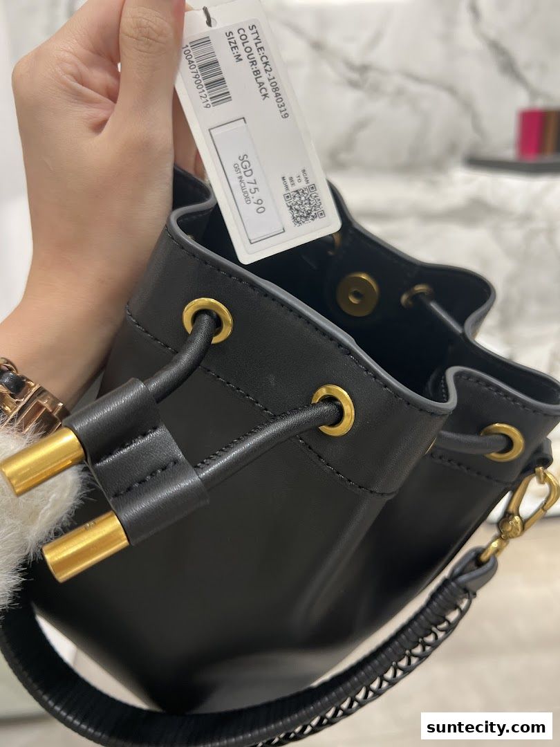 A black bucket bag with gold hardware and a price tag from Charles Keith.