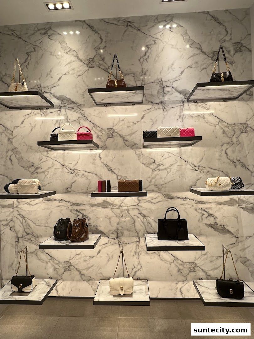 A display of various Charles & Keith handbags on marble-patterned shelves.