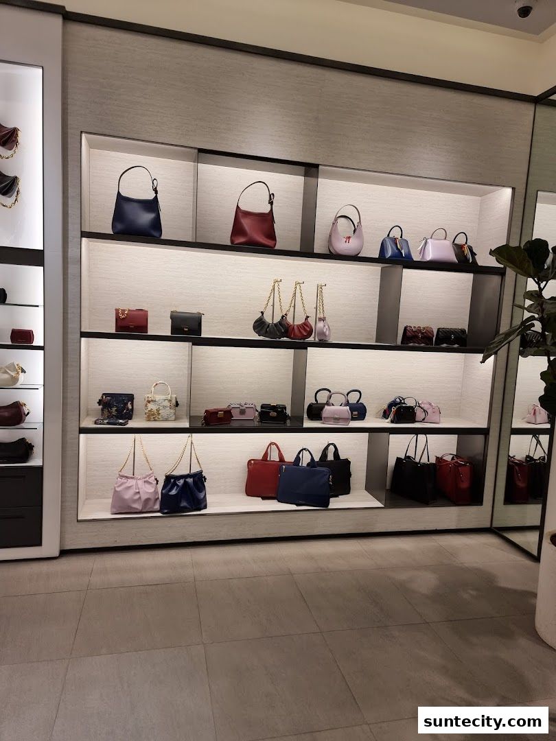 A display of various handbags on shelves in a retail store.