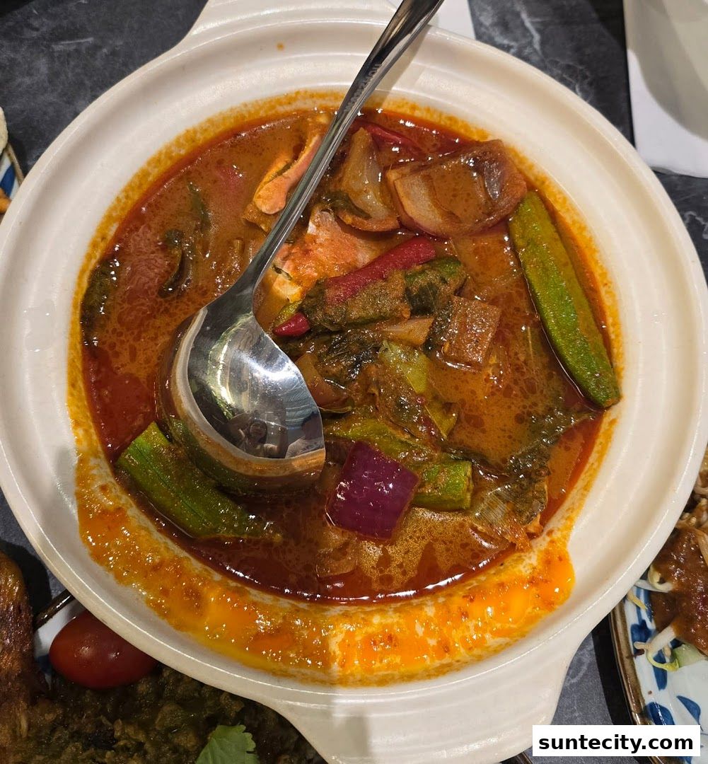 A close-up of a flavorful Indonesian curry dish with okra, onions, and chili.