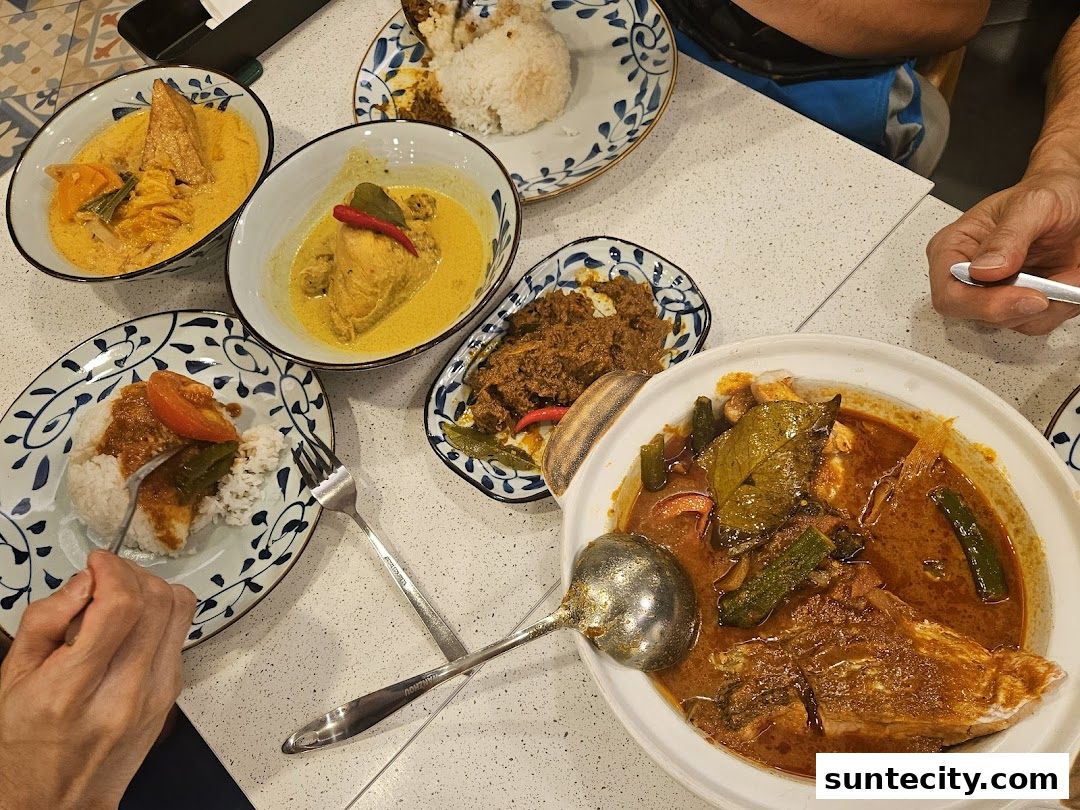 A table laden with various Indonesian dishes, including curries, rice, and meat.
