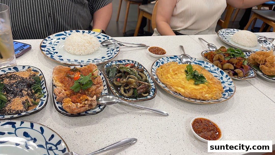 A table laden with various Indonesian dishes, including rice, omelets, and stir-fried vegetables.