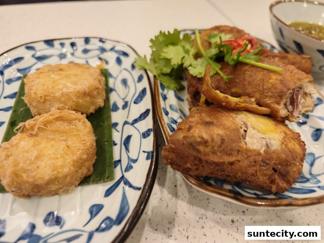 Two plates of Indonesian food, featuring fried chicken and crispy fritters, garnished with cilantro.