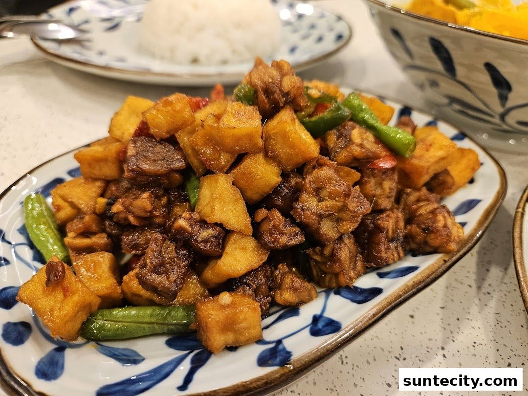 A close-up of a delicious Indonesian dish with tempeh, sweet potatoes, and green beans.