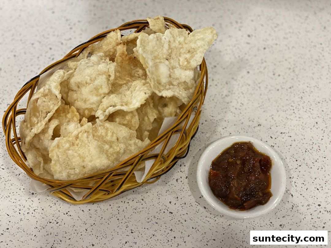 A basket of crispy crackers served with a side of spicy sambal chili paste.