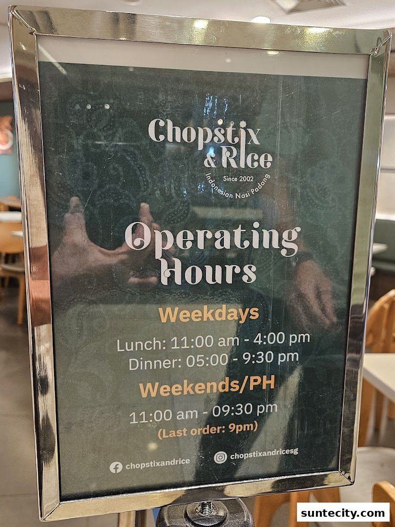 A sign displaying the operating hours for Chopstix & Rice Indonesian Restaurant.