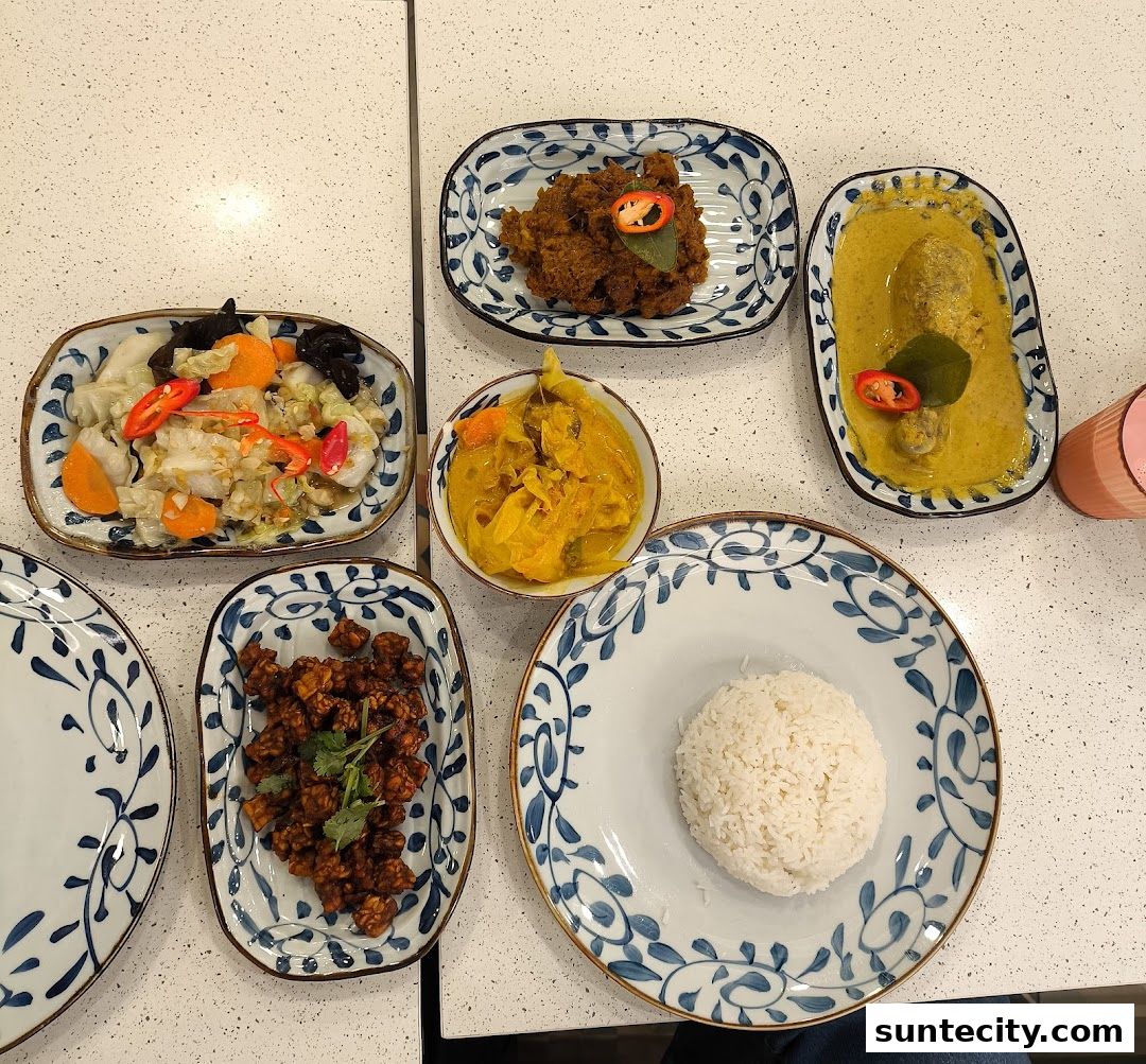A spread of Indonesian dishes including rice, curry, and stir-fried vegetables.